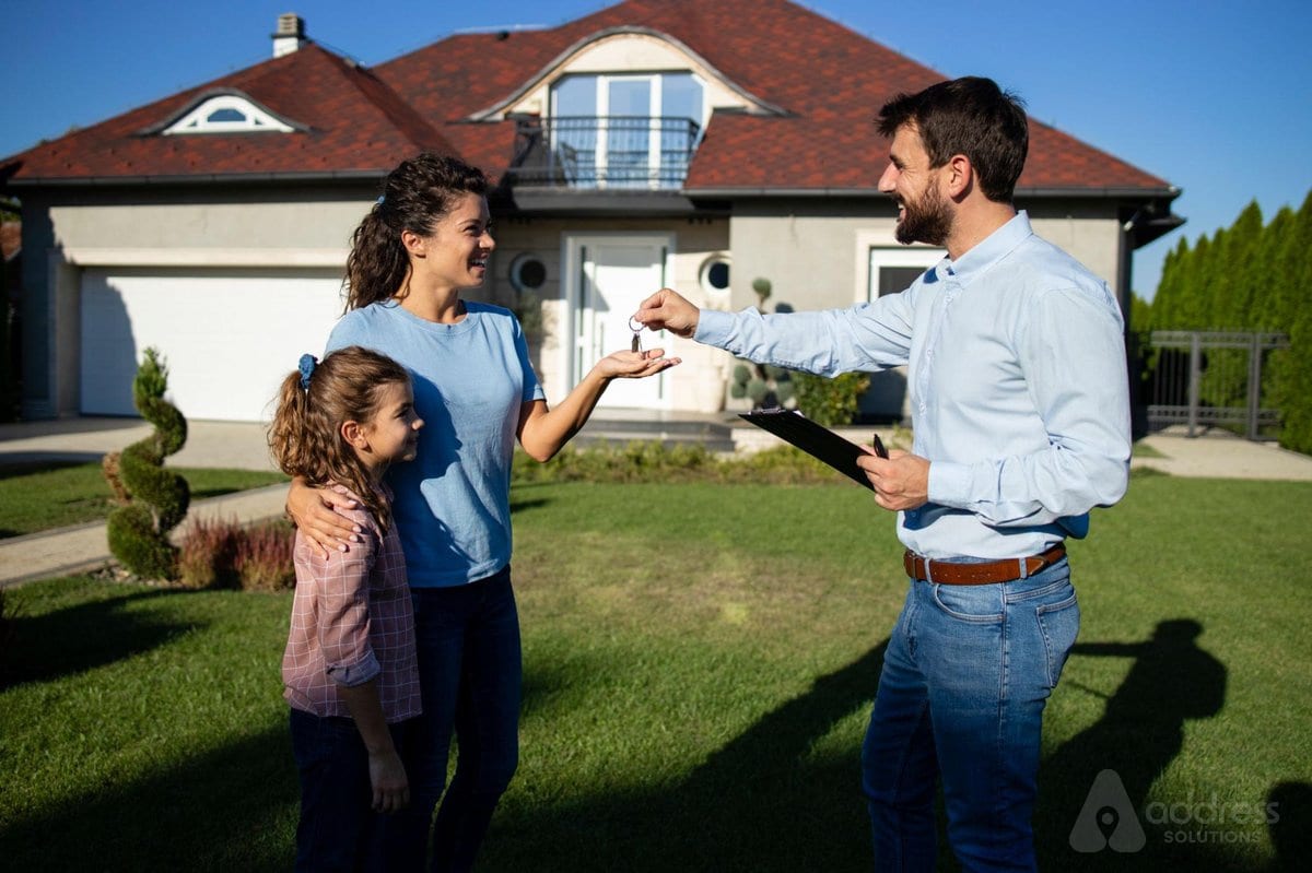 Real estate agent handing over house keys to a happy family